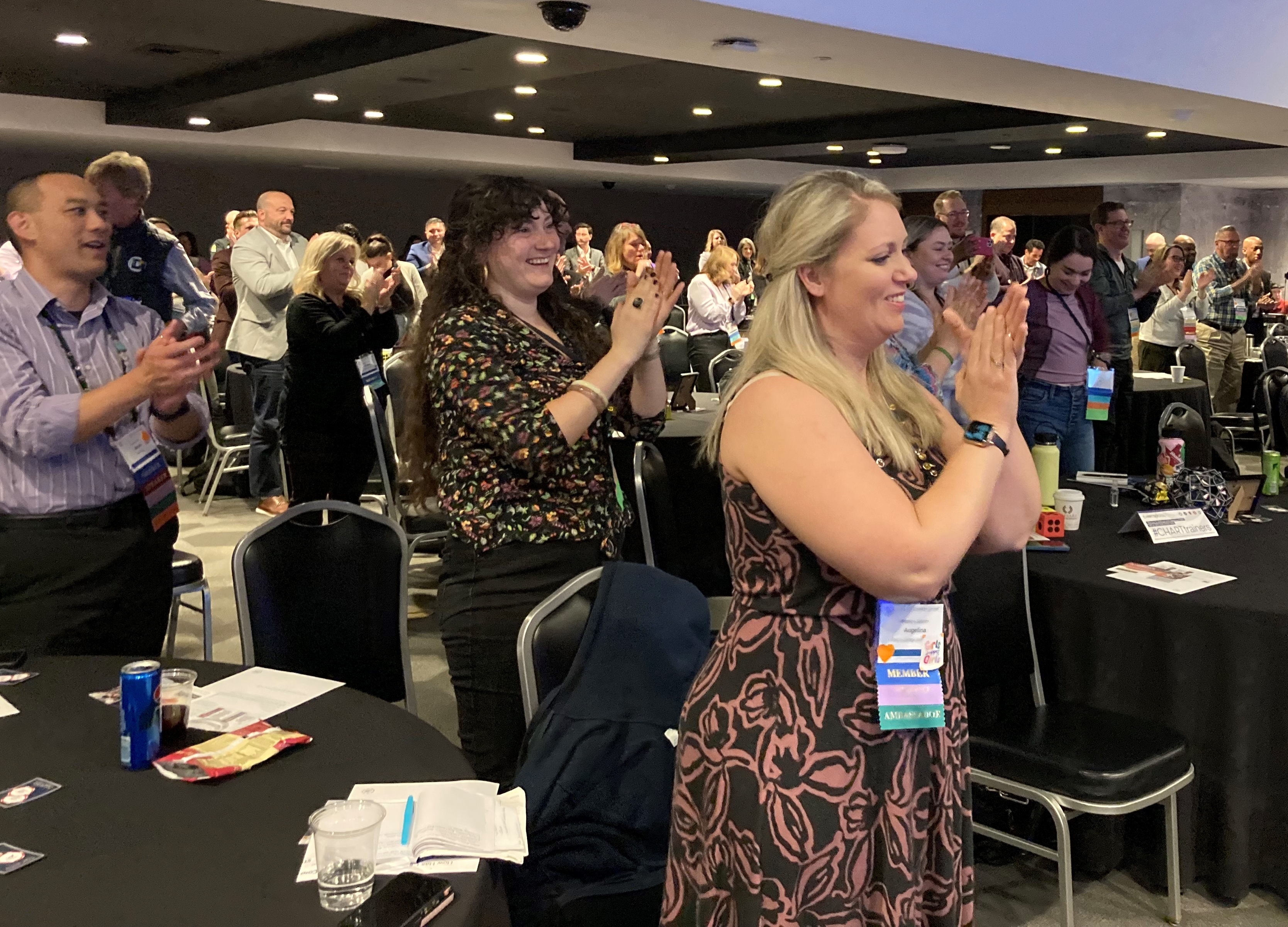 Conference attendees stand, clap, and cheer